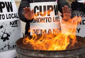 Canada Post workers warming up their hands