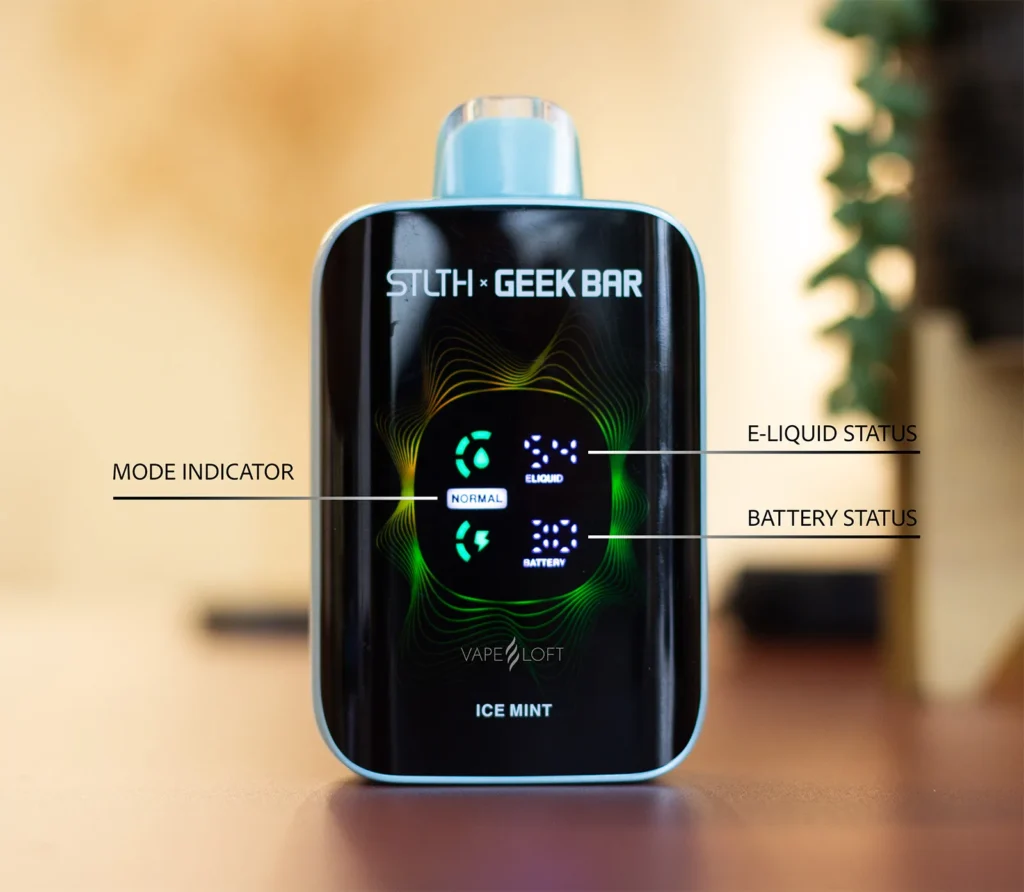 Close-up of a vape device displaying mode, e-liquid, and battery status indicators on a sleek screen.