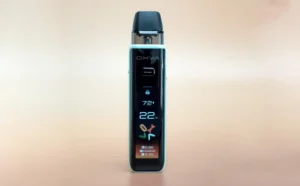 A sleek vape device with a digital display showing settings, including temperature and wattage, against a soft background.